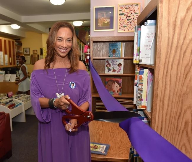 Michelle Hord with a large pair of scissors opening the New Rochelle branch Gabrielles corner